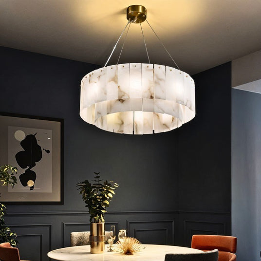 The lit drum above a round table in a deep blue room with artwork