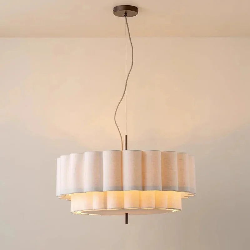 White drum pendant light on its ceiling plate and cord against a plain ceiling