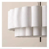 Close view of the rounded scalloped lobes on the white fabric drum shade