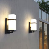 Two lights lit on a gray facade beside a tall window