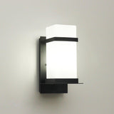 The light unlit on a pale wall, the white glass and the black frame