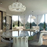 Layered silk pendant lit over a glass dining table