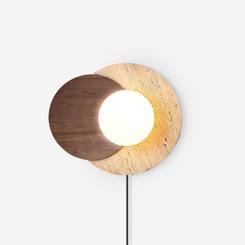 White plug in wall sconce, a glass orb between a walnut and a travertine disc