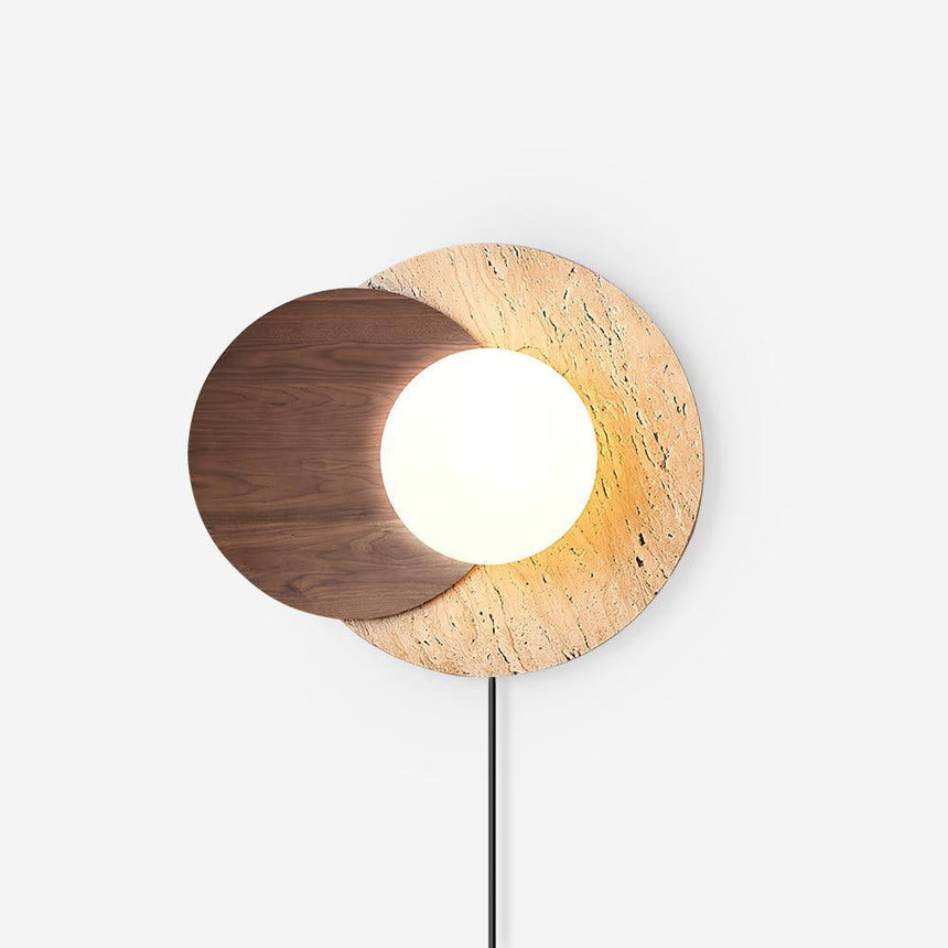 White plug in wall sconce, a glass orb between a walnut and a travertine disc