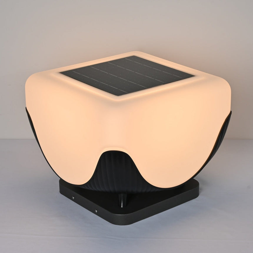 The lit body glowing above the fluted base on a pale studio table top