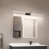 Dark bar lit above a lit mirror cabinet over a basin on a gray tiled wall