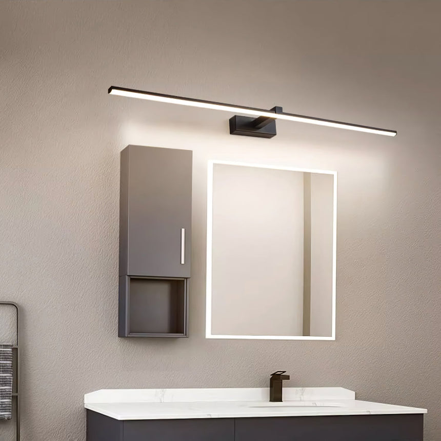 Dark bar lit above a lit mirror cabinet over a basin on a gray tiled wall