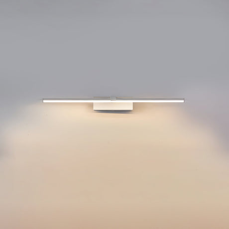 The short white bar lit on a gray wall, the glow pooling under the fitting