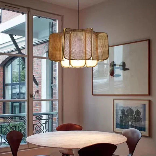 Wicker hanging lamp above a round dining table by a window
