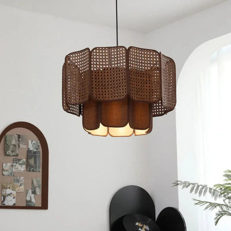 Wicker hanging lamp with a two tier scalloped shade in brown, lit in a room