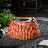 The lantern lit on gravel with a garden table and chairs behind it