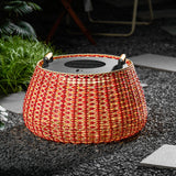 The lantern lit on gravel with clumps of grass and a paving slab beside
