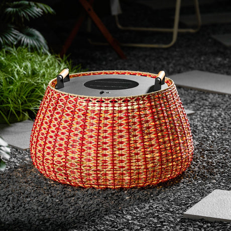 The lantern lit on gravel with clumps of grass and a paving slab beside