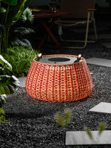 The lantern lit on dark gravel beside pale stepping stones and grasses