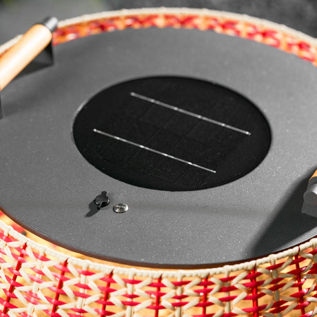 The gray lid with its solar cell and the wooden handle on the weave