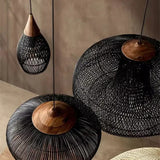 Two black wicker domes hung side by side in a pale room