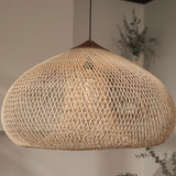 Wicker pendant light in a natural woven dome above a pale interior