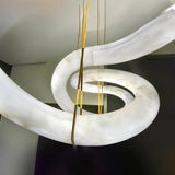 The alabaster ribbon at the point where the brass cables meet the stone