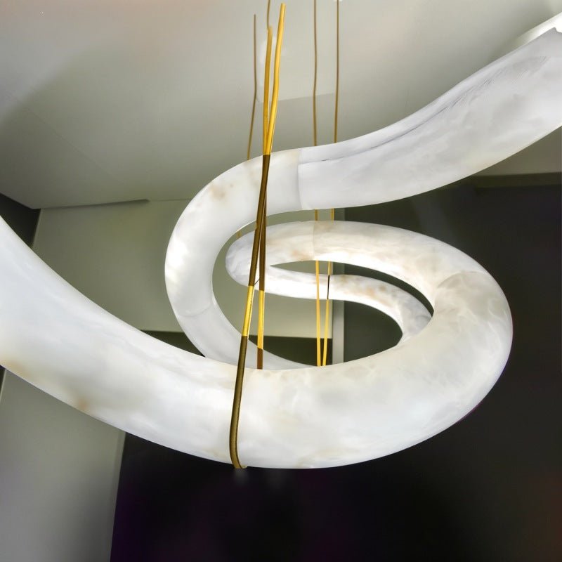 The alabaster ribbon at the point where the brass cables meet the stone