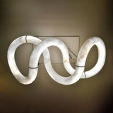 The winding ribbon lit against a dark ground, the loops of stone clearly visible