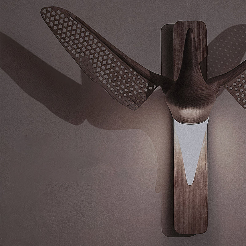 The pierced wings throwing a patterned shadow across a dark wall