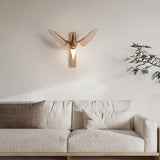 Sconce lit above a pale sofa against a plain plaster wall