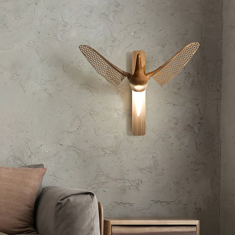 Sconce lit above a low bench beside cushions on a plaster wall