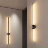 Two rods lit along a hallway wall beside a doorway and a run of pale doors