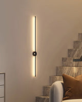 Lit on a warm wall beside a staircase and a curved seat with cushions