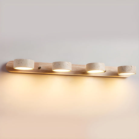 Four travertine discs lit along a long light wood bar