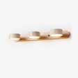 Wireless wall sconce with three travertine discs on a light wood bar