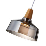 Close view of the smoked glass bell shade under its wooden cap