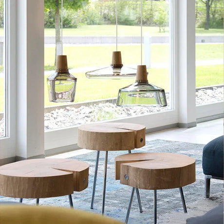Three smoked glass and wood pendants lit above round cafe tables