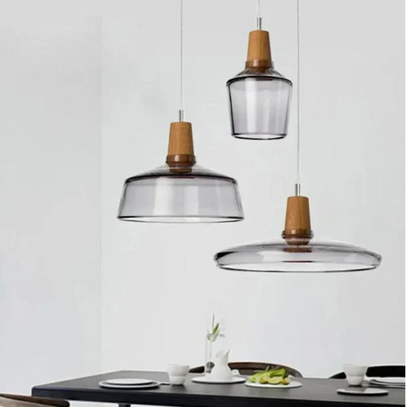 Three smoked glass pendants of different shapes hung above a counter