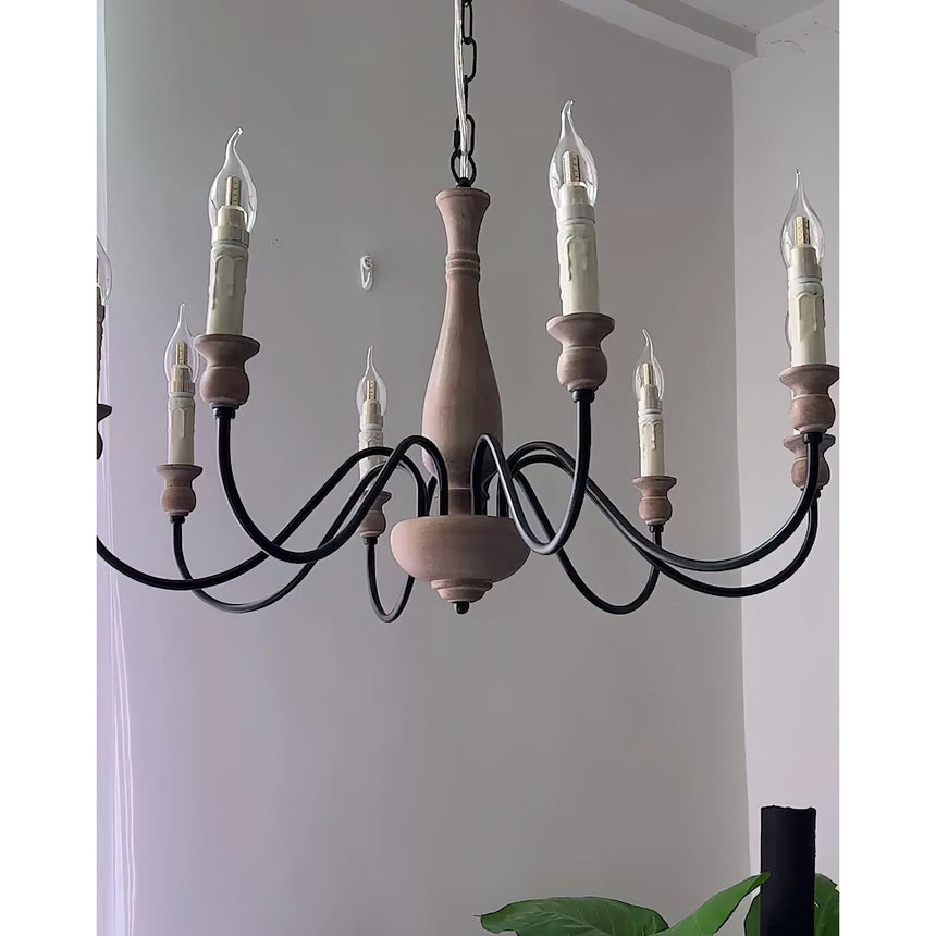 The arms and candle sleeves seen against a pale wall with a plant below