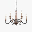 Six black arms looping out of a pale turned wood column with candle sleeves on top
