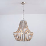The fitting lit in a plain white room, showing the chain and the round canopy