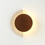 The travertine crescent lit brightly around a dark walnut disc