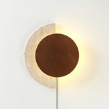 Walnut disc lit over a travertine crescent, warm halo around the edge