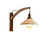 The curved walnut arm and pleated shade on a white background