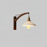 The curved arm lamp lit on a pale gray background