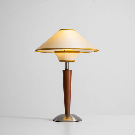 Beige shade wood table lamp switched on, the fabric glowing evenly