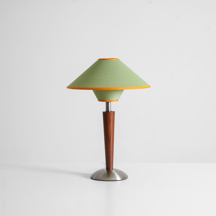 Wood table lamp with the green two tier shade on a plain background