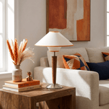 Wood table lamp on a console table beside a pale sofa