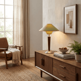 Wood table lamp lit on a wooden sideboard in the evening