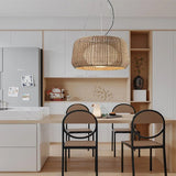 The lit shade above a pale kitchen table with two black chairs and open shelving