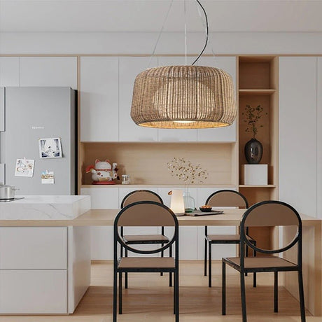 The lit shade above a pale kitchen table with two black chairs and open shelving
