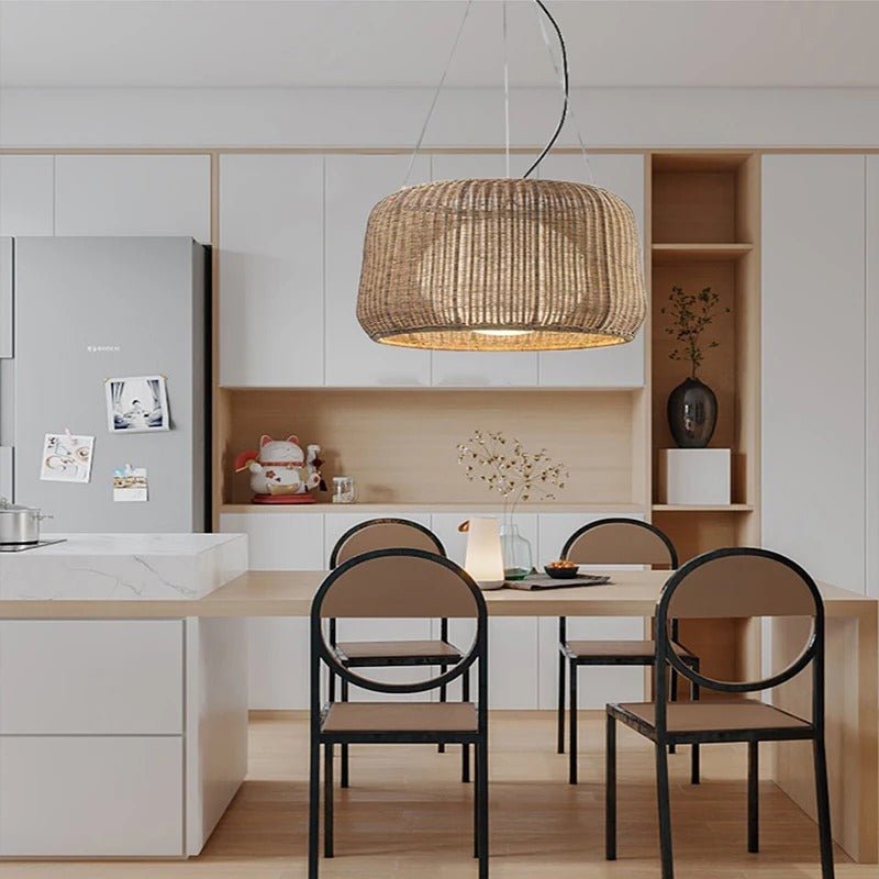 The lit shade above a pale kitchen table with two black chairs and open shelving