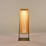 The woven shade glowing warm against a plain pale studio background