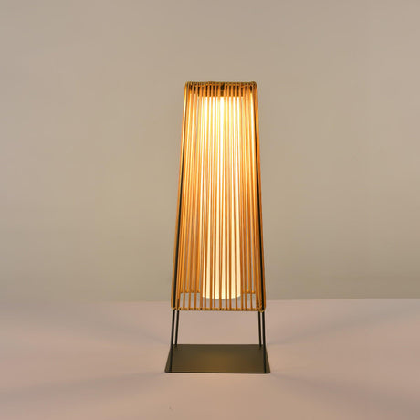 The woven shade glowing warm against a plain pale studio background